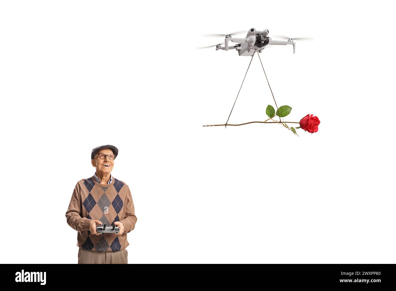 Ein älterer Mann, der eine Drohne mit einer Fernbedienung fliegt und eine rote Rose auf weißem Hintergrund abgibt Stockfoto