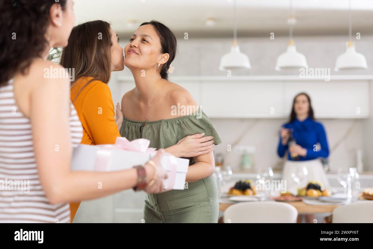 Lächelnde asiatische Frau küsst die Bestie, die zu einer freundlichen Party kommt Stockfoto