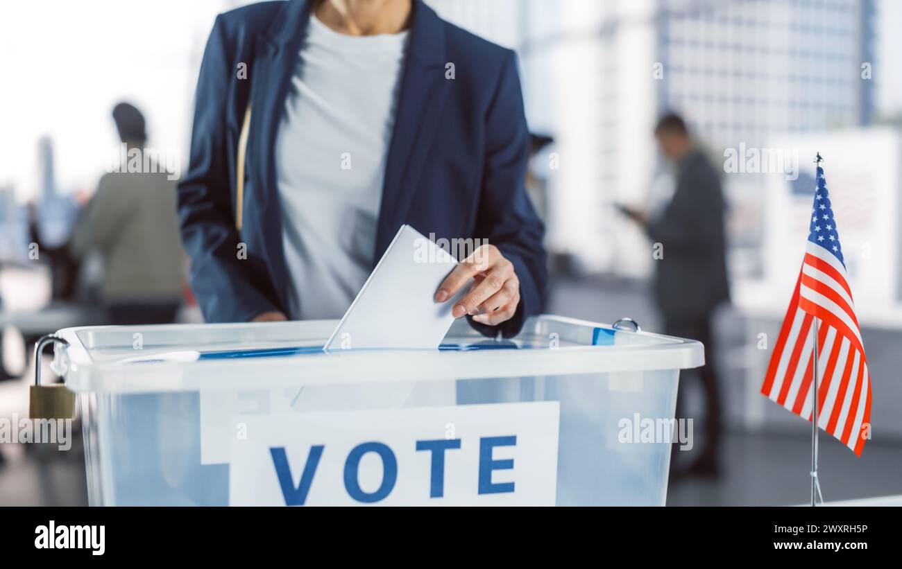 Amerikaner besuchen am Wahltag eine Wahlstation in der Hauptstadt der Vereinigten Staaten von Amerika. Weibliche kaukasische Wählerin, die ihre Stimme ausgibt und in eine transparente versiegelte Box passt Stockfoto