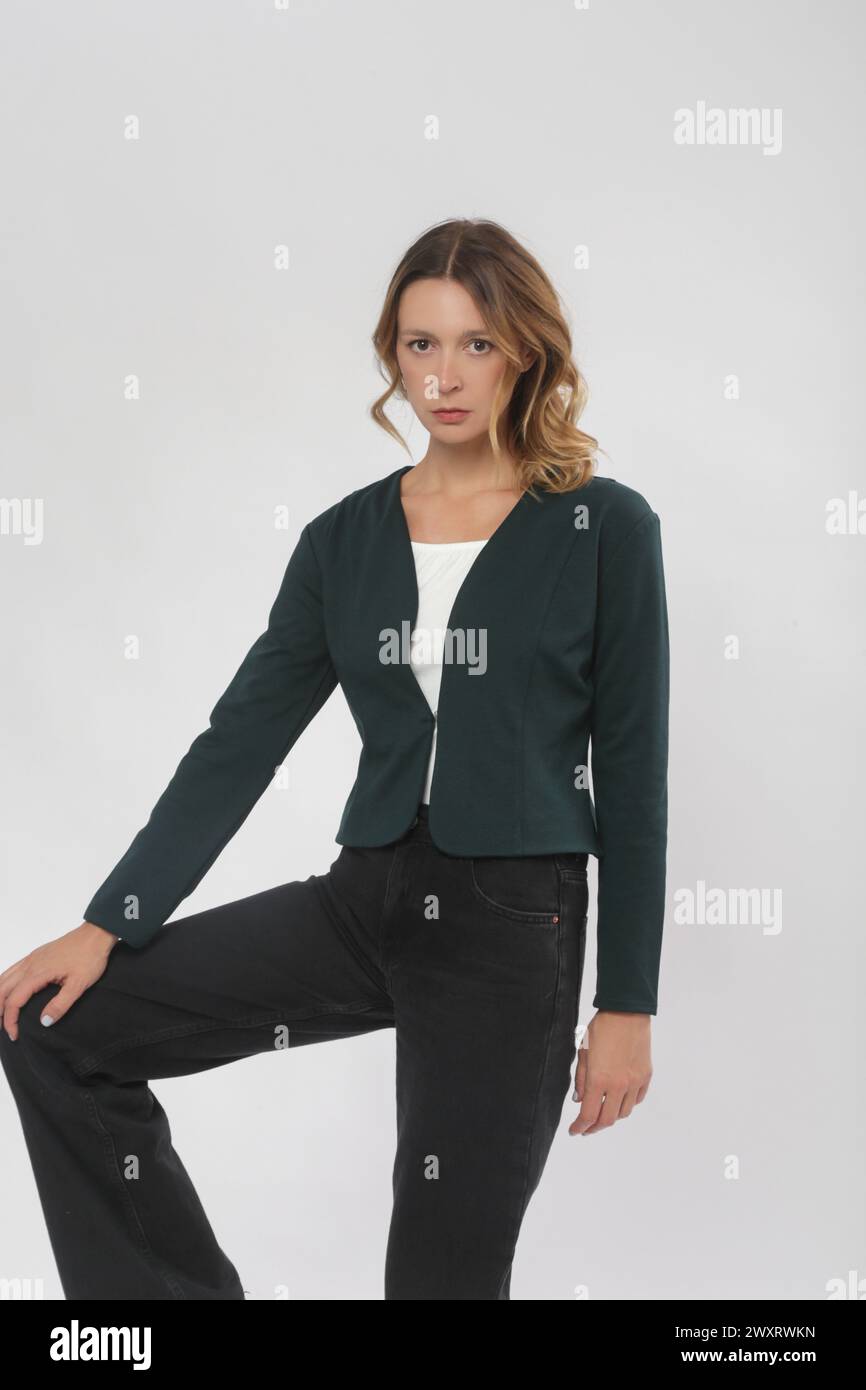 Serie von Studiofotos eines jungen weiblichen Models mit bequemem, elegantem, legeren Outfit, schlichtem, minimalistischem Blazer und Jeanshose Stockfoto