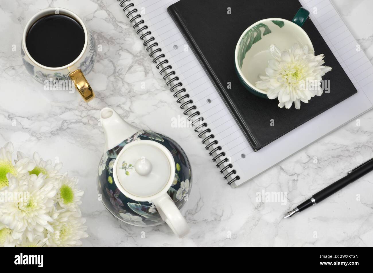 Kaffee, weiße Blumen, Notizbuch, Stift auf einem Tisch, flach. Stockfoto