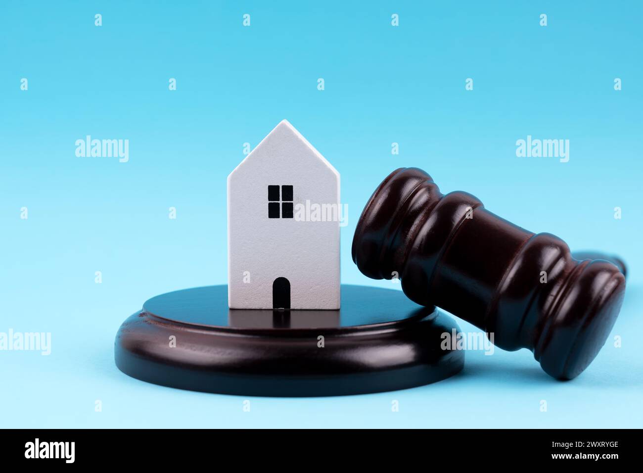 Modellhaus, Hammer und Block auf blauem Hintergrund Stockfoto