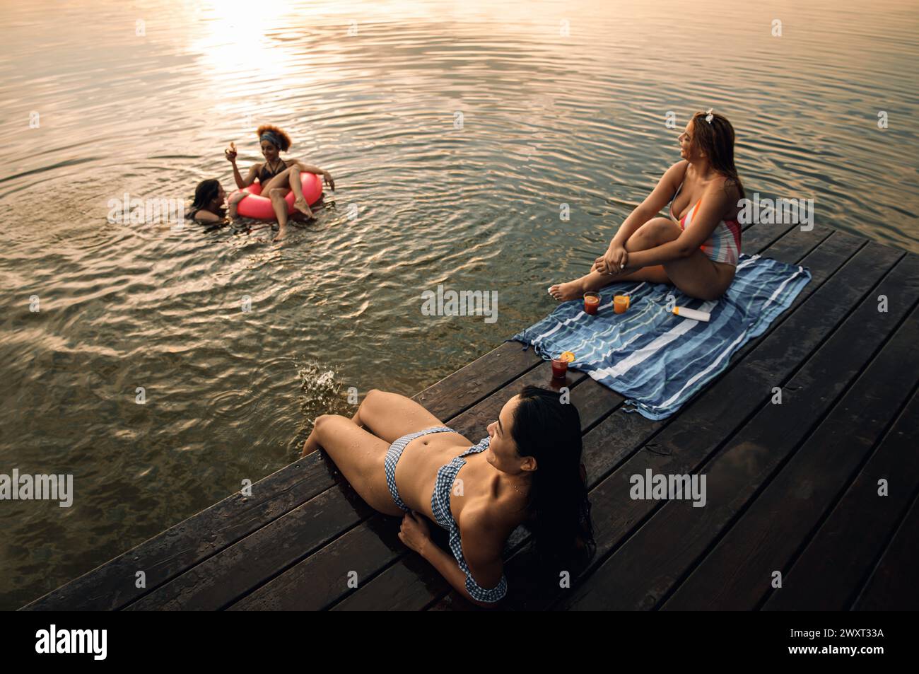 Gruppe weiblicher Freunde, die einen Sommertag am See verbringen. Stockfoto