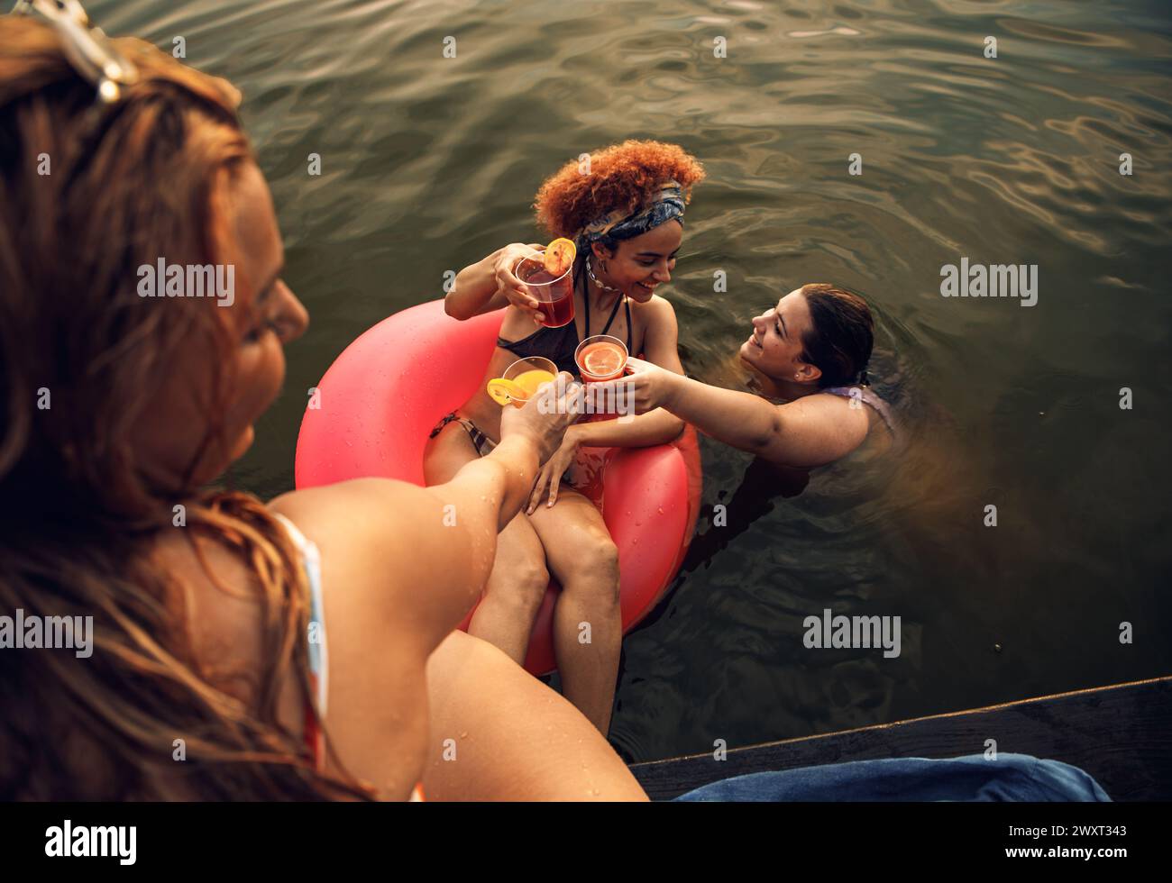 Gruppe weiblicher Freunde, die einen Sommertag am See verbringen. Stockfoto