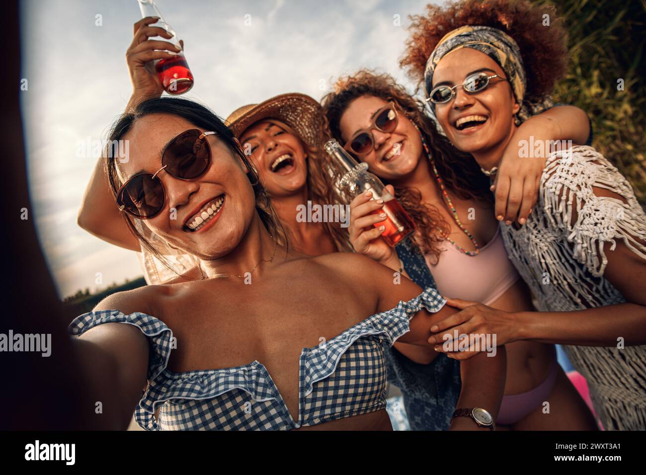 Eine Gruppe weiblicher Freunde genießt einen Sommertag am See und macht Selfie mit dem Smartphone. Stockfoto