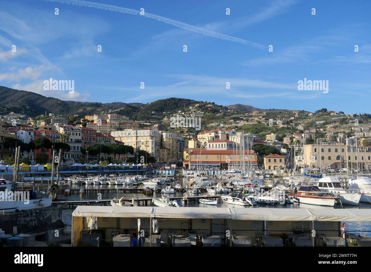 Einige Boote auf dem Wasser mit Gebäuden und Hügel im Hintergrund Stockfoto