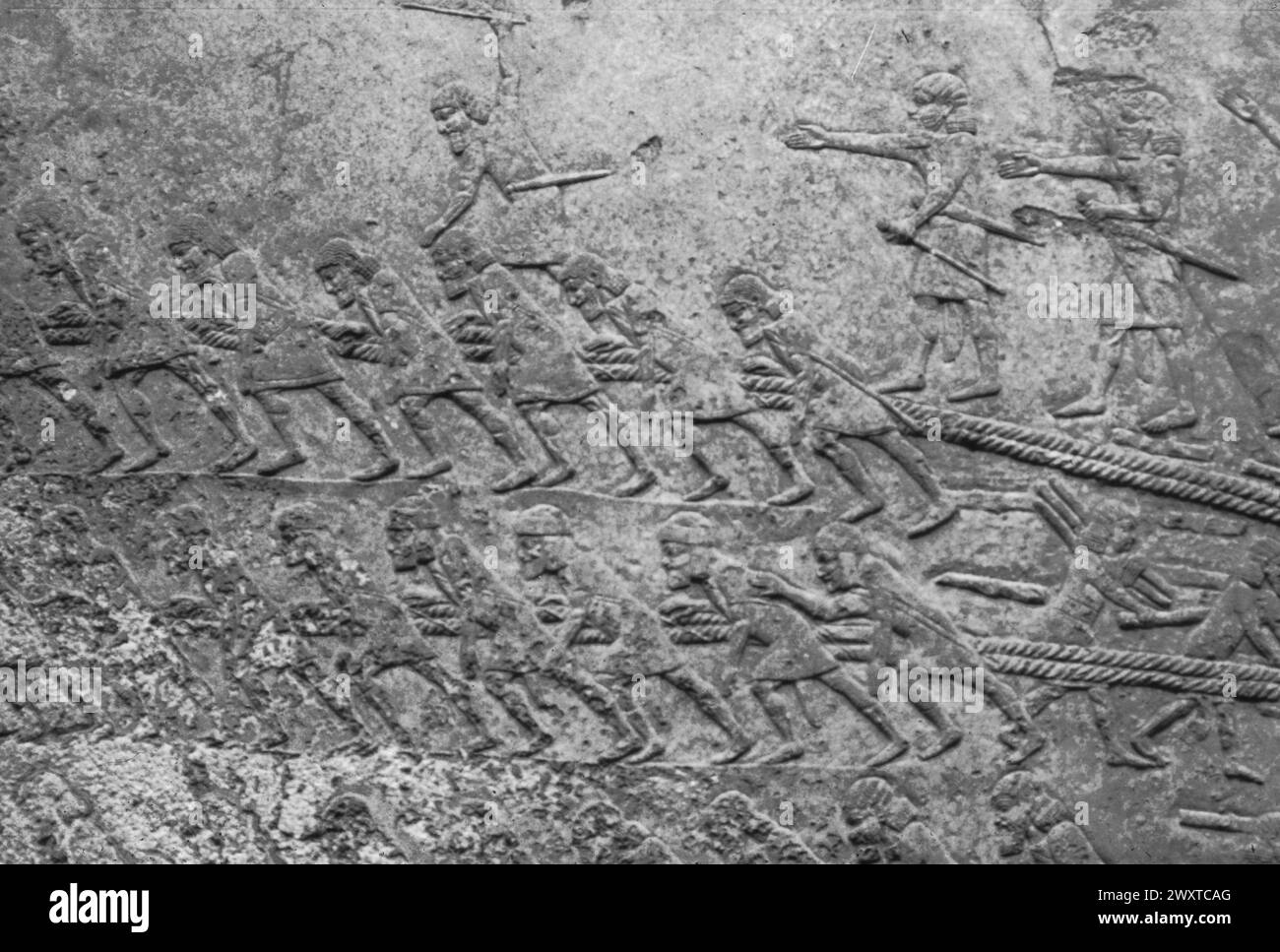 Sklavenbanden schleppen eine Stiersphinx für den Bau des Palastes, des Basreliefs, des Sanherib-Palastes, Ninive, Mesopotamien Stockfoto