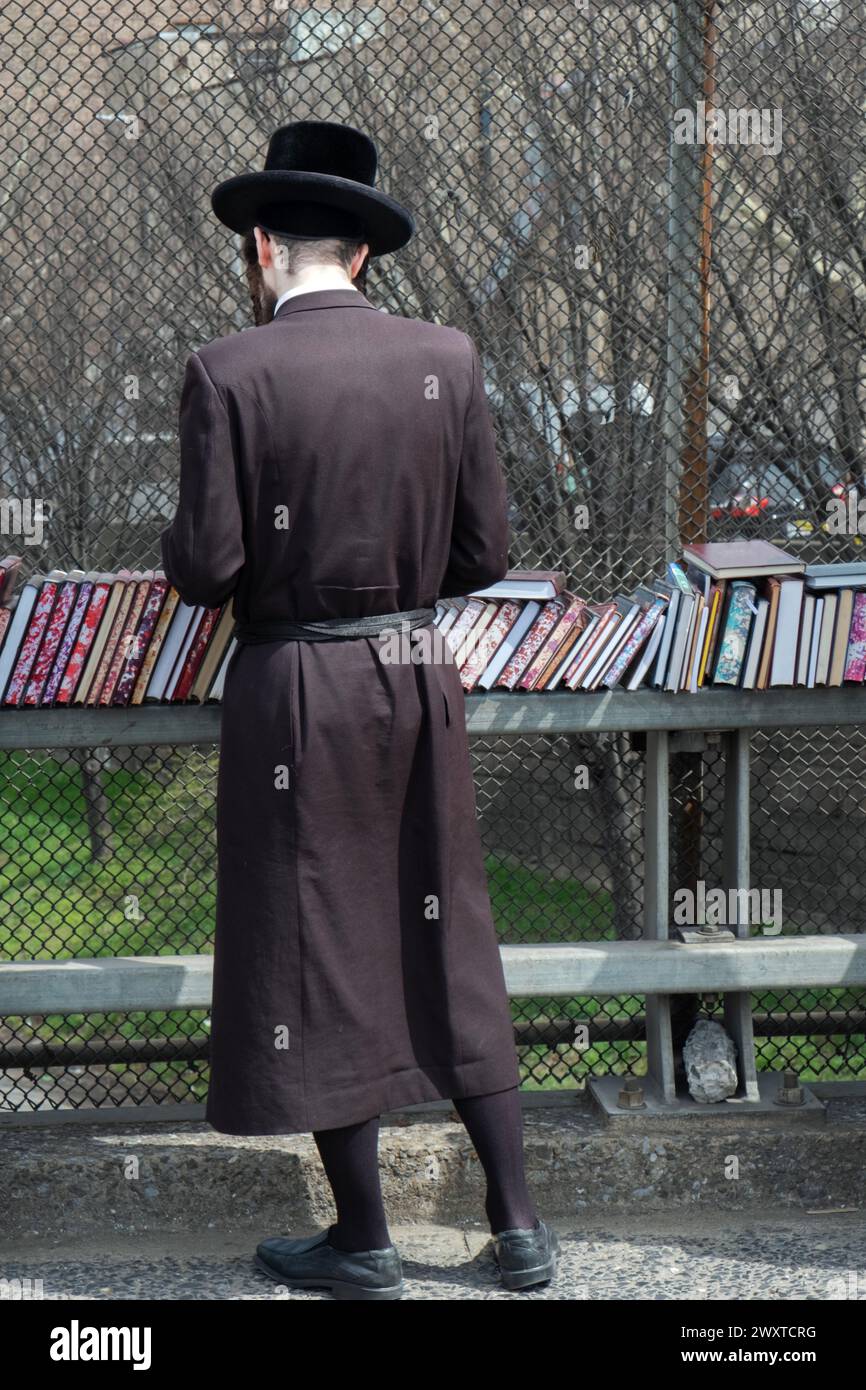 An einem warmen frühen Frühlingstag kaufen orthodoxe jüdische Männer in einem Pop-up-Geschäft religiöse Bücher ein. Auf der BQE-Überführung in Brooklyn, New York. Stockfoto