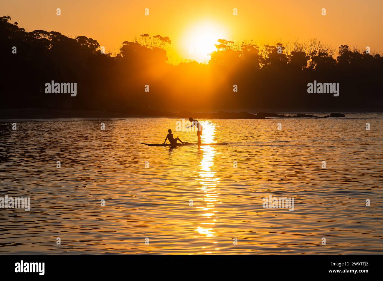24.03.30-Manyana Beach at Sunset, 214 KM südwestlich von Sydney, NSW, Australien. Silhouetten von Einheimischen, die sich entspannen. Der Strand von Manyana verläuft von Manyana Villag Stockfoto