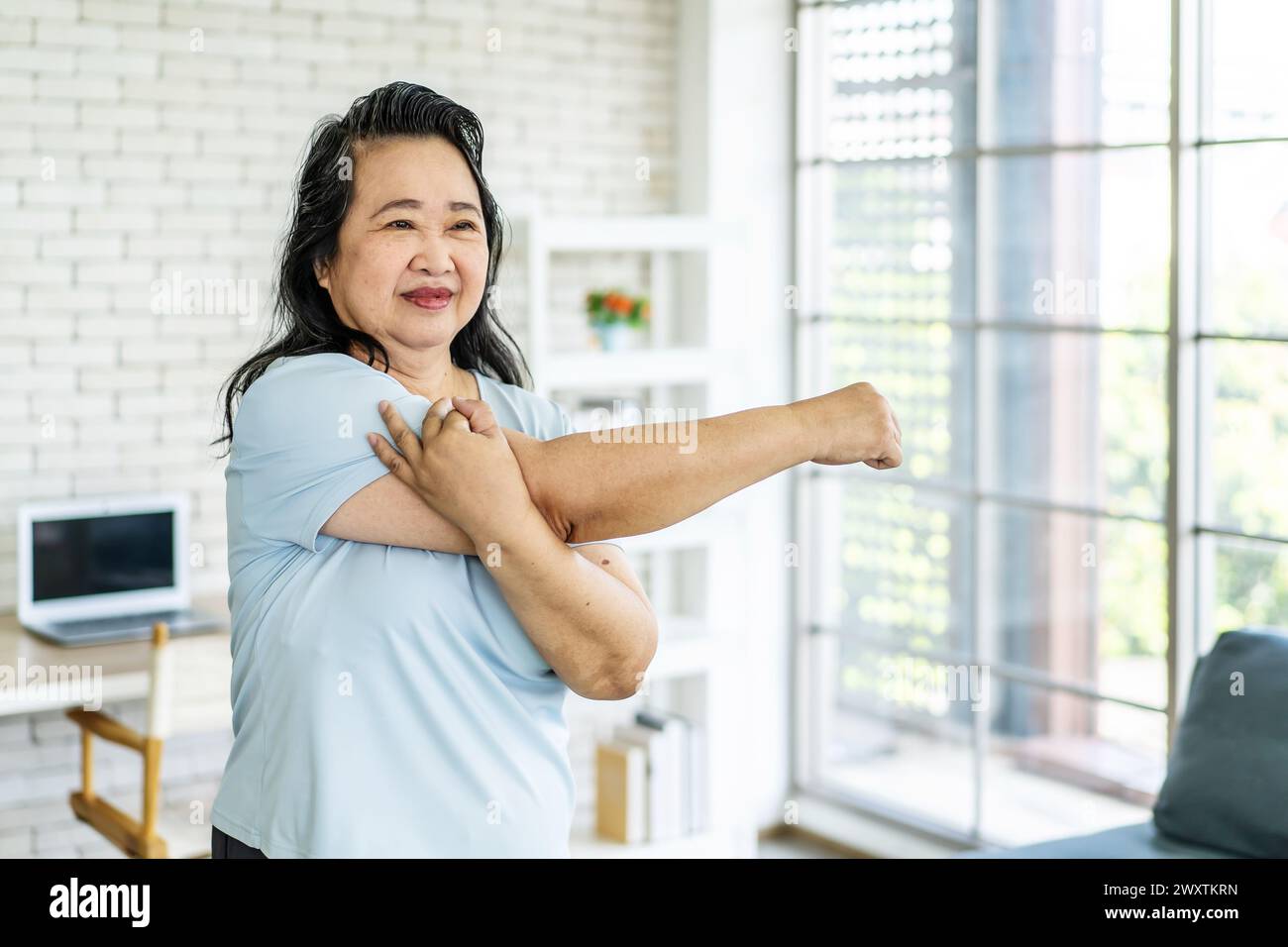 Eine schöne und lächelnde asiatische Frau beim Heimtraining Stockfoto