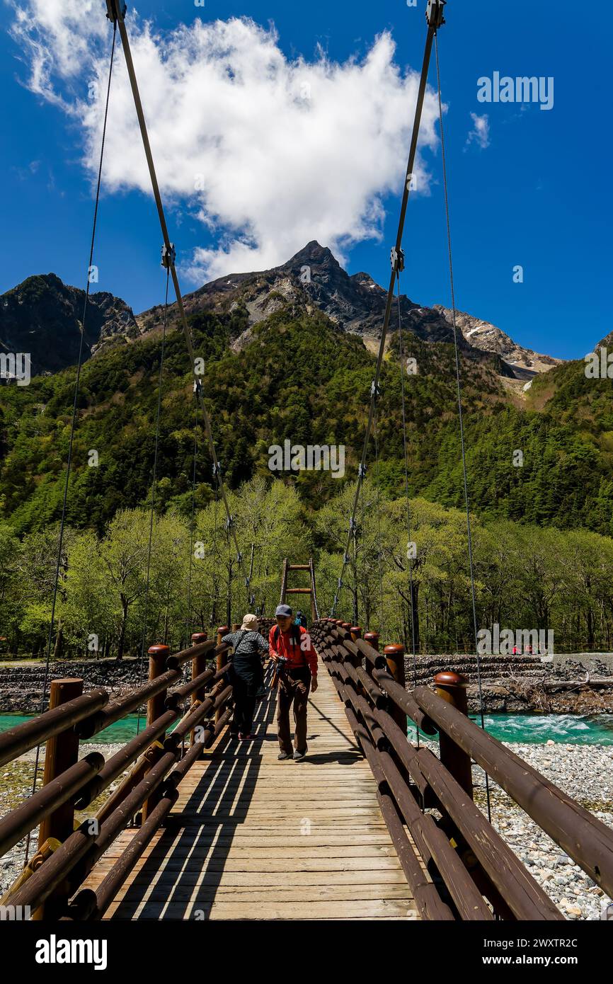 KAMIKOCHI, JAPAN - 24. MAI 2023: Wanderer überqueren die Myojin-Hängebrücke über den Azusa-Fluss in Kamikochi, Nagano, Japan Stockfoto