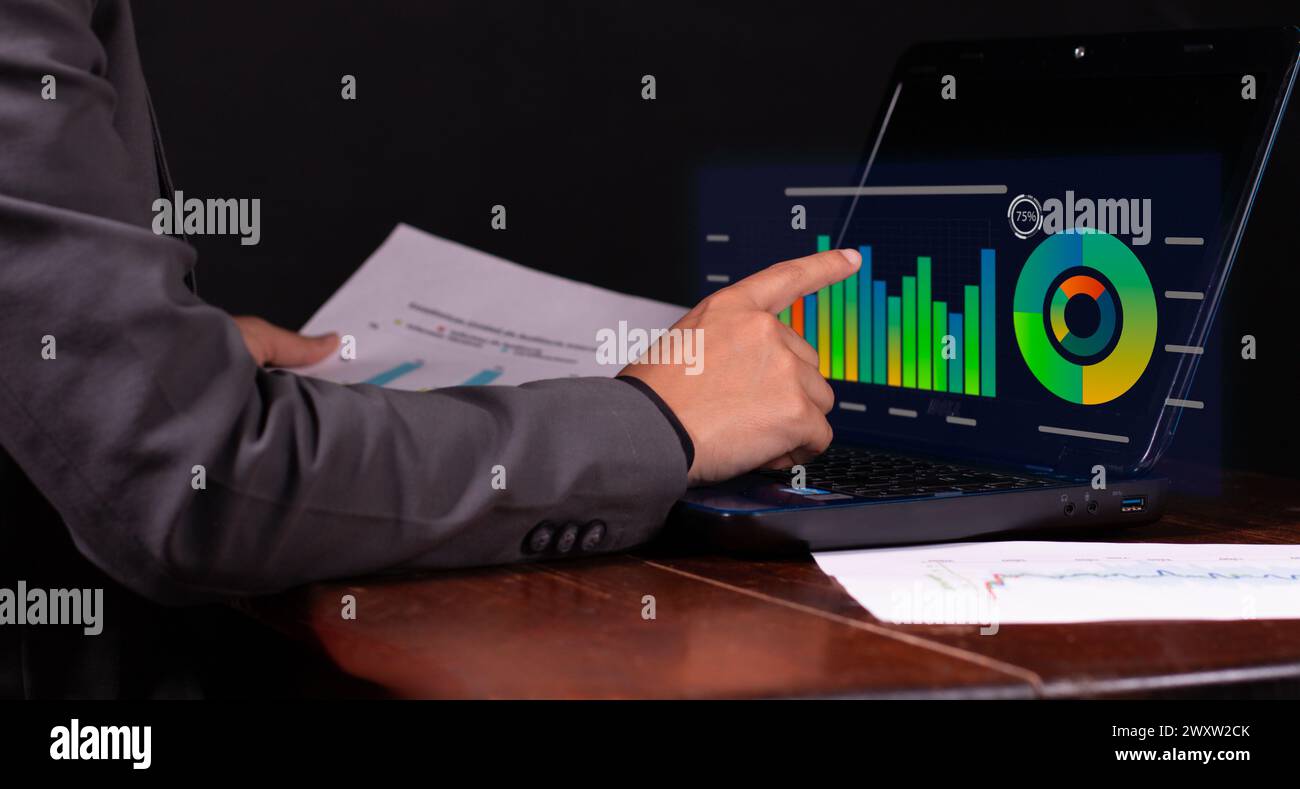 Geschäftsmann berät Finanzdaten, monatliche Diagramme. Schwarzer Hintergrund des Büros Stockfoto