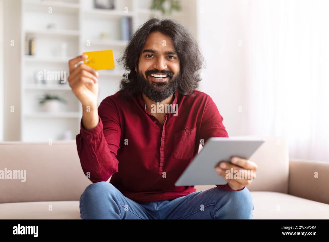 Der Mann zeigt gerne Kreditkarte und Tablet Stockfoto