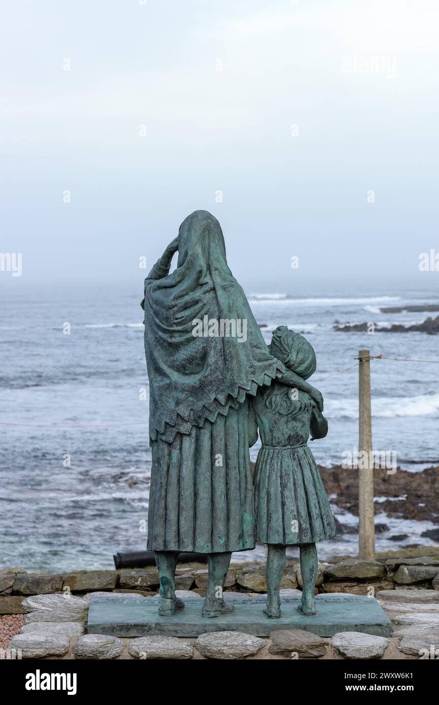 Gedenkstatue einer fischerfrau und ihrer Tochter, die auf das Meer blickt, geschaffen zum Gedenken an die Verlorenen in Cairnbulg, Aberdeenshire, Schottland. Stockfoto