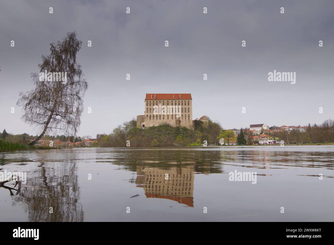 Historisches Schloss Plumlov aus dem 17. Jahrhundert und Reflexion auf der Oberfläche des Teiches im Bezirk Prostejov in Tschechien. Rauchluftverschmutzung Himmel. Stockfoto