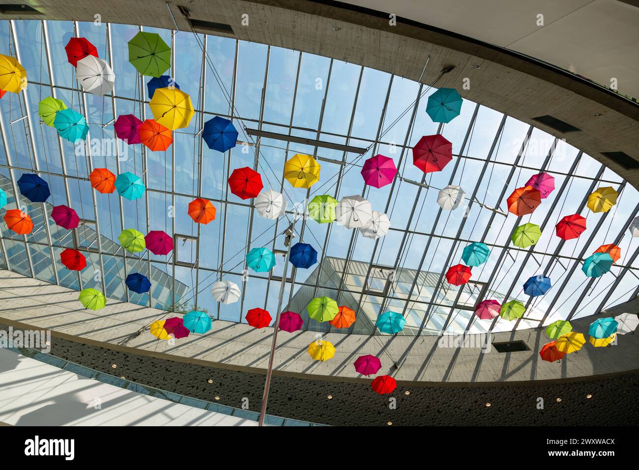 Installation von bunten Regenschirmen unter dem Dach des Einkaufszentrums Stockfoto