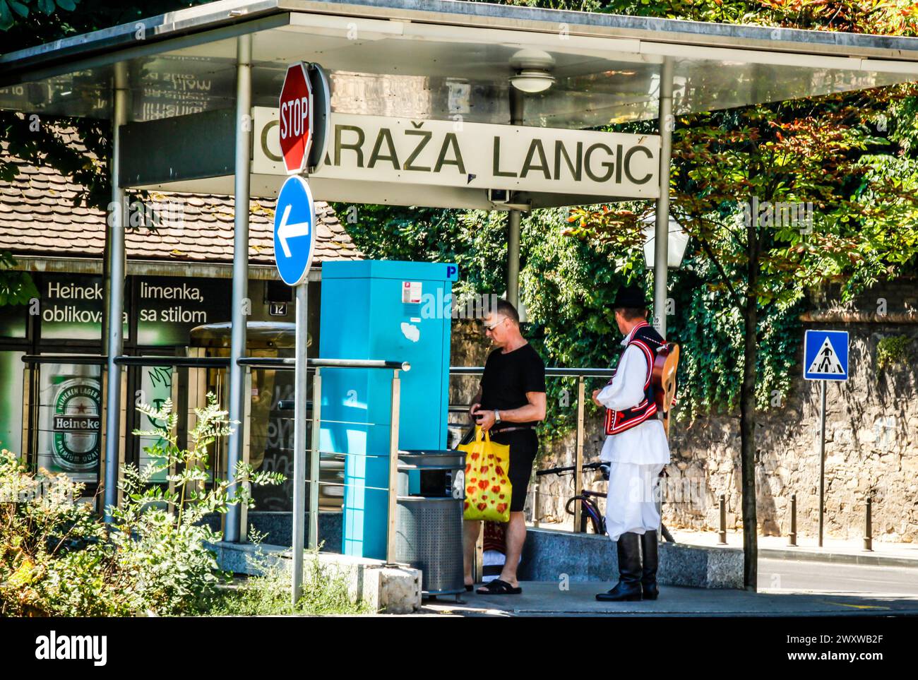 Zufälliger Mann an der Seite verkleidet Mann in kroatischen Insignien an einer Straßenbahnhaltestelle und einem Ticketautomaten in der Innenstadt von Zagreb in Kroatien Stockfoto