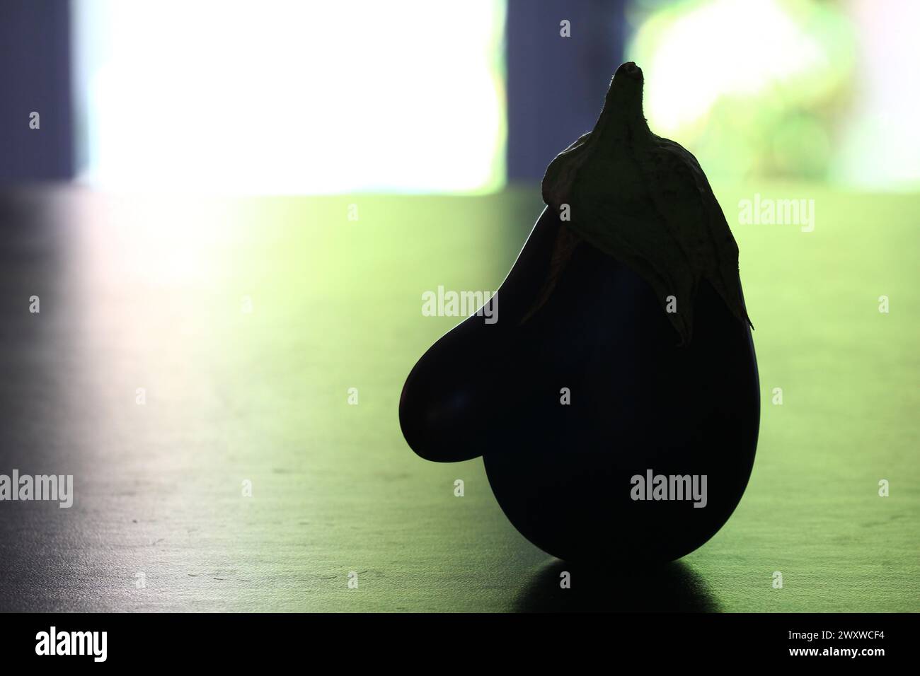 Gegen das Licht erinnert eine Aubergine auf einer flachen Oberfläche an ein Profil mit einer großen Nase und einem spitzen Hut (Montpellier, Frankreich). Stockfoto