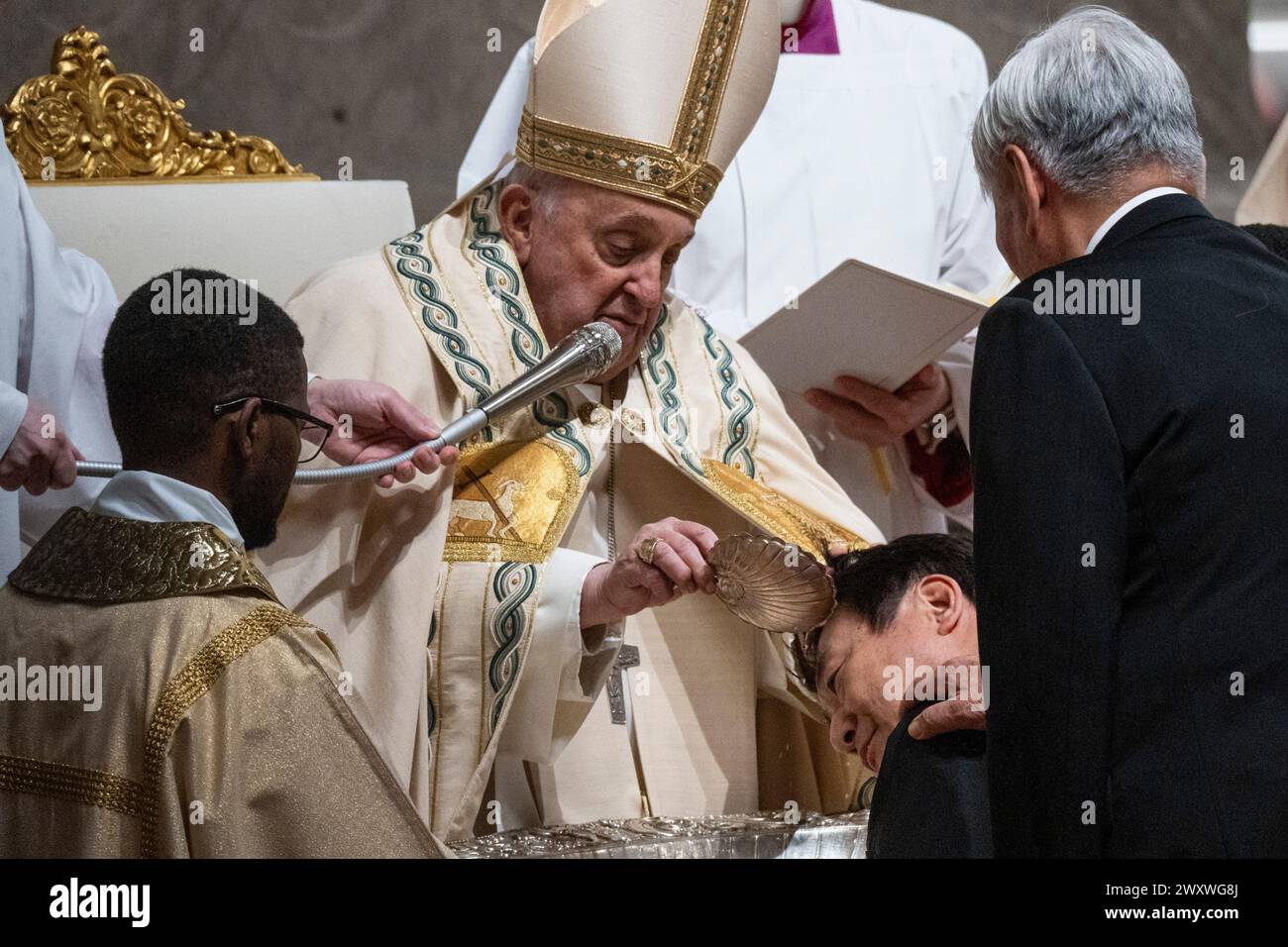 Papst Franziskus tauft einen Gläubigen während der feierlichen Ostervigil-Zeremonie. Christen auf der ganzen Welt feiern die Karwoche, gedenken der Kreuzigung Jesu Christi, die bis zu seiner Auferstehung an Ostern führt. Stockfoto