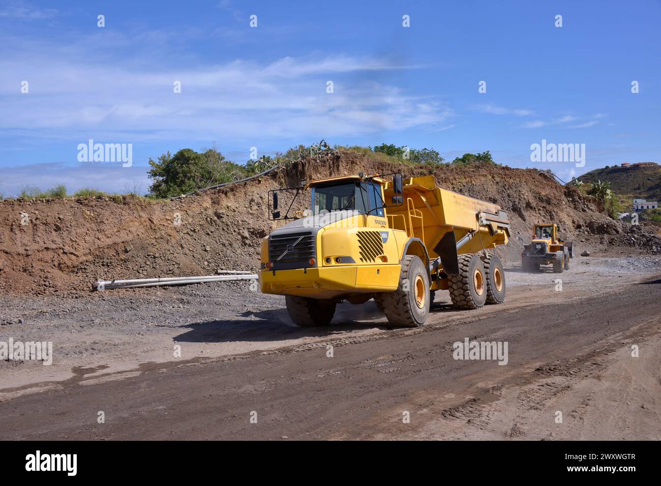 Große Lkw bewegen Erde beim Bau einer Straße auf den Kanarischen Inseln Stockfoto