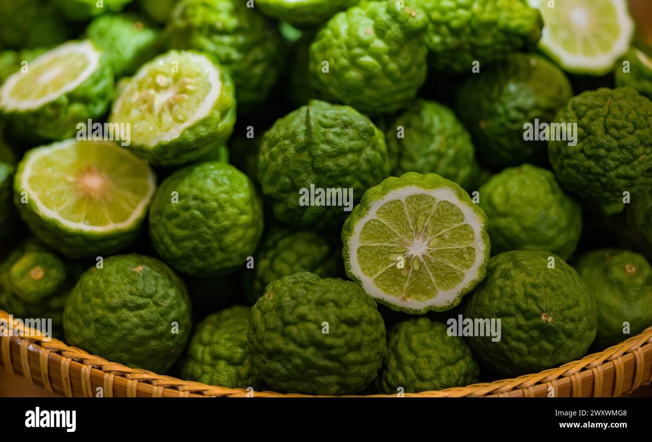 Stapeln Sie in einem Korb mit aromatischen Gewürzen aus Kafir Lime oder Citrus trifoliata bei balinesischer Küche. Wellness- und Food-Konzept Stockfoto