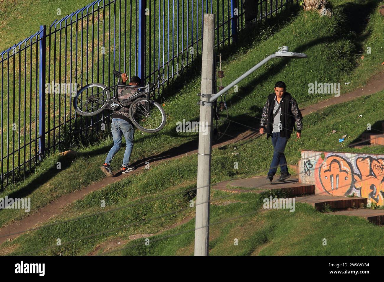 Bogota, Kolumbien, 24-01-2024. Ein Radfahrer klettert auf sein Fahrrad, lädt sein Fahrrad auf dem Rücken, während er einen Hügel hinaufklettert, um sein Zuhause in einem Viertel von Bogot zu erreichen Stockfoto