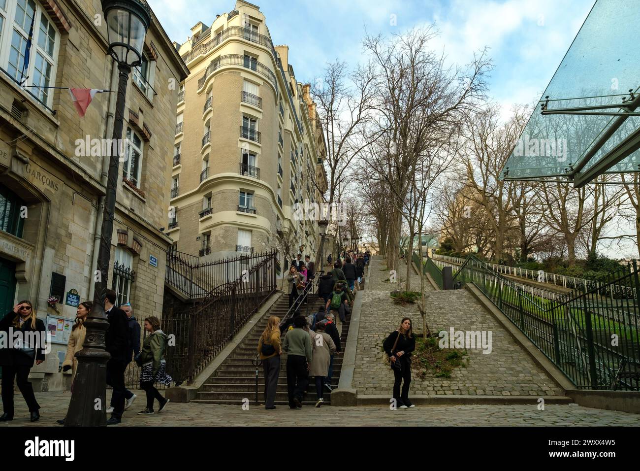 Paris, Frankreich - 17. Februar 2024 : Panoramablick auf Touristen, die die malerischen Treppen neben einer Standseilbahn in Montmartre Paris hoch- und hinunterlaufen Stockfoto