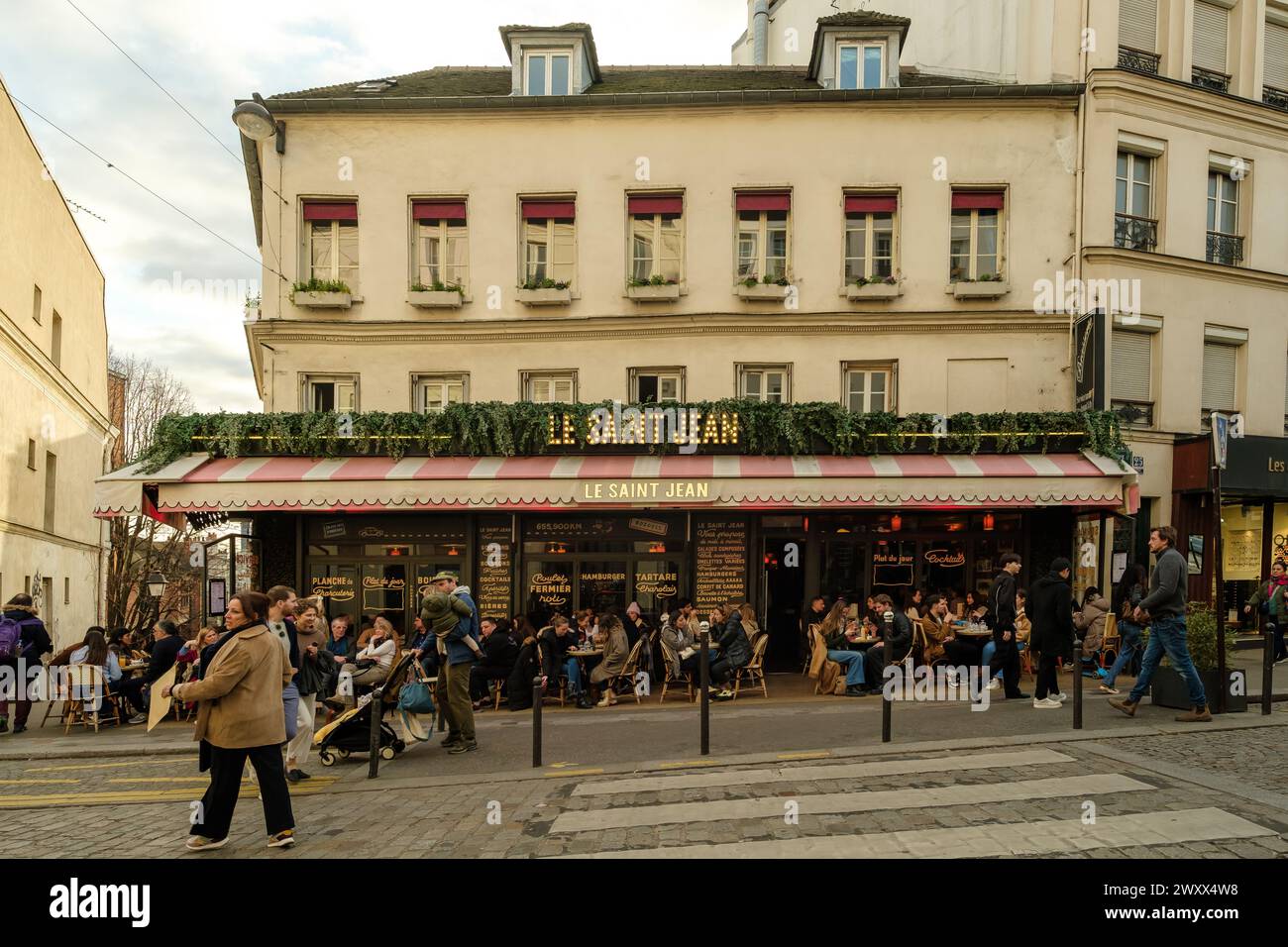 Paris, Frankreich - 17. Februar 2024 : Blick auf die Menschen, die draußen sitzen und in einem Café-Restaurant-Bistro in Paris Frankreich Abendessen und Getränke genießen Stockfoto