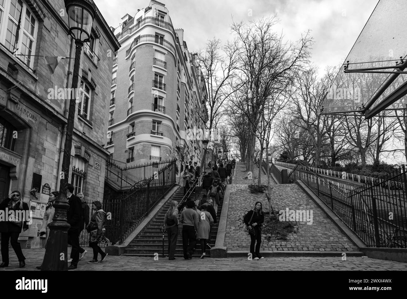 Paris, Frankreich - 17. Februar 2024 : Panoramablick auf Touristen, die die malerischen Treppen neben einer Standseilbahn in Montmartre Paris hoch- und hinunterlaufen Stockfoto