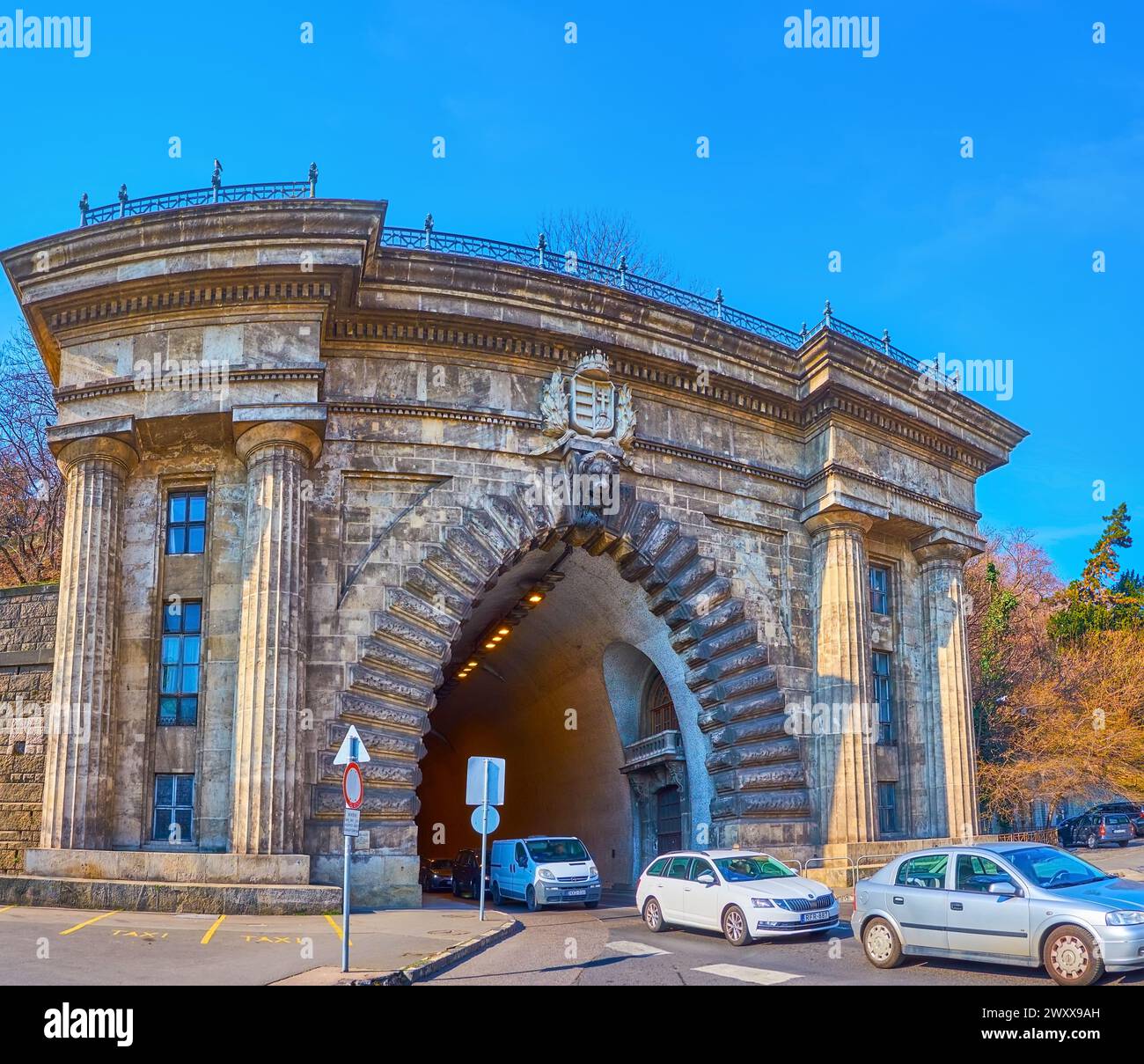 BUDAPEST, UNGARN - 3. MÄRZ 2022: Das Haupttor des Budaer Schlosstunnels, verziert mit Wandsäulen, Skulptur des Löwenkopfes und ungarischem Wappen Stockfoto