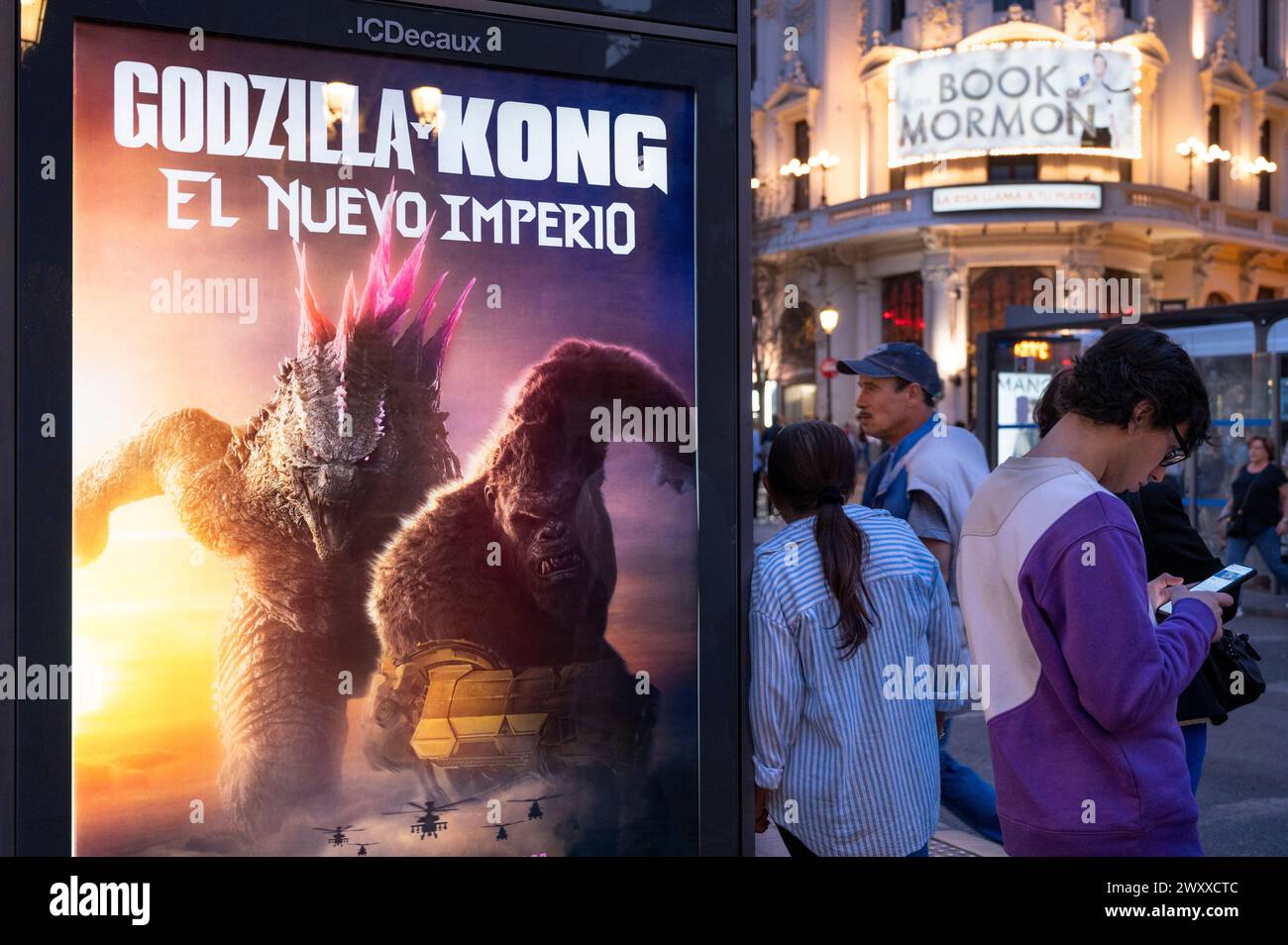 24. März 2024, Madrid, Spanien: Menschen werden neben einer Bushaltestelle mit einer Werbeanzeige gesehen, in der der Film Godzilla x Kong: Das neue Reich gezeigt wird, produziert von Legendary Pictures und vertrieben von Warner Bros. (Credit Image: © Xavi Lopez/SOPA Images via ZUMA Press Wire) NUR REDAKTIONELLE VERWENDUNG! Nicht für kommerzielle ZWECKE! Stockfoto