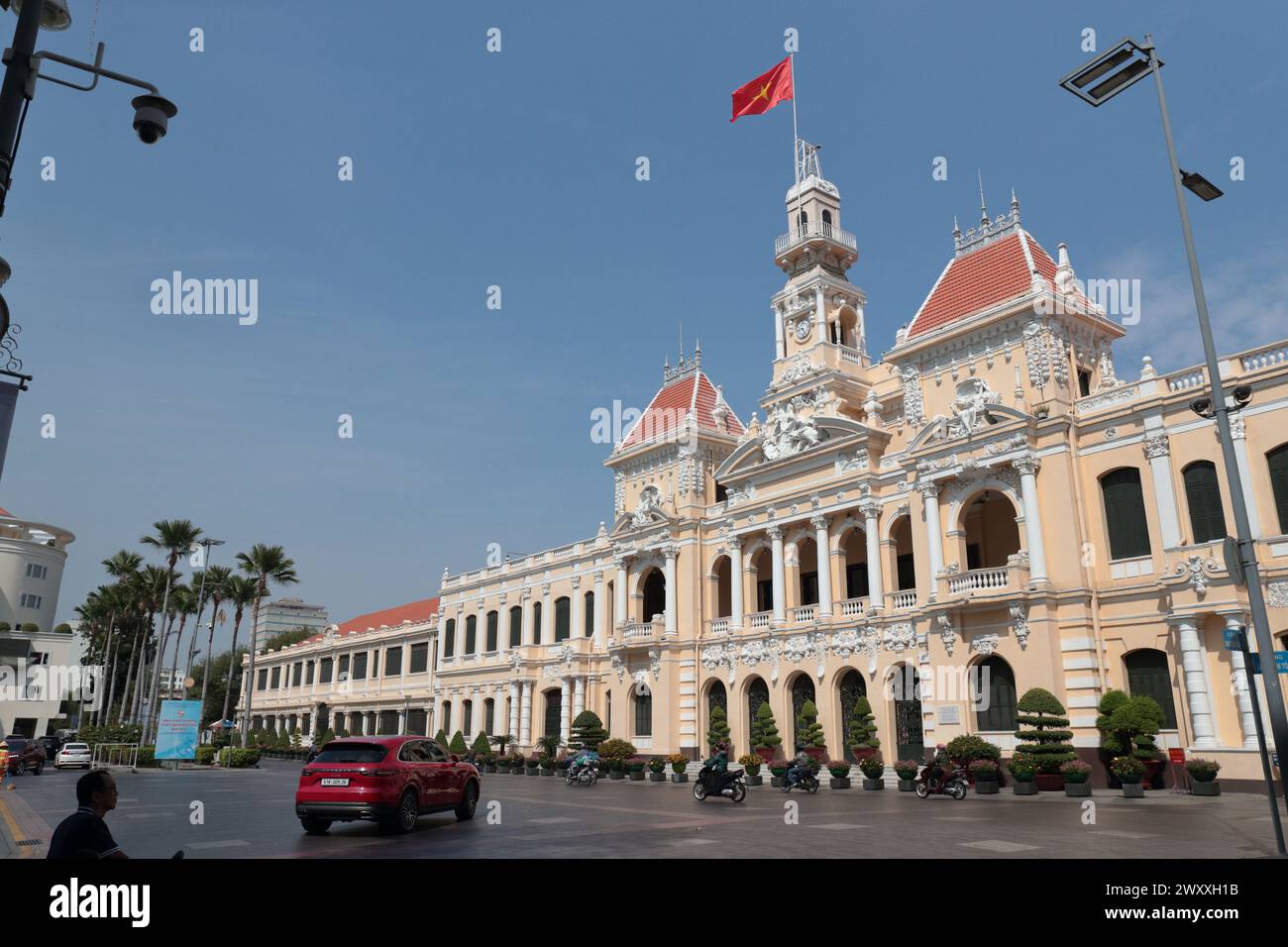 Außenansicht des Peoples Committee Building, Sonnenschein und blauer Himmel, die vietnamesische Nationalflagge fliegt, Ho Chi Minh City (Saigon), Vietnam Stockfoto
