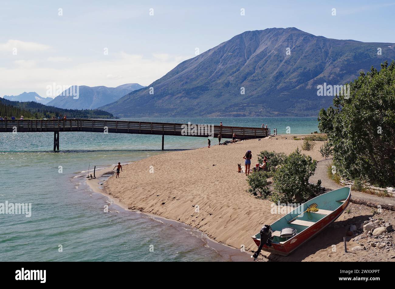 Boot, Fußgängerbrücke an einem Sandstrand, Bennett Lake, Yukon Territory, Kanada Stockfoto