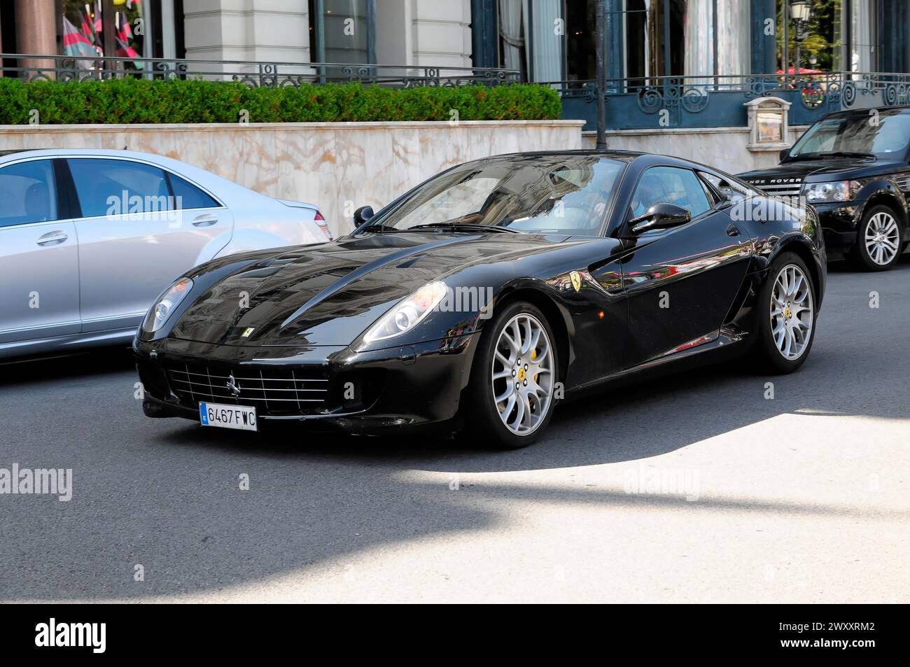 Ein geparkter schwarzer Ferrari in einem städtischen Ort strahlt unter der Sonne, Monte Carlo, Fürstentum Monaco, Monaco Stockfoto