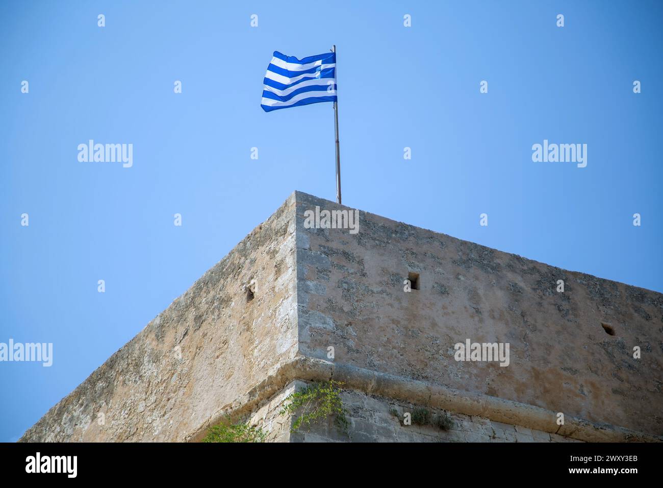 Koules Venezianische Festung am alten Hafen von Heraklion, Ziel der Insel Kreta Griechenland. Griechische winkende Flagge auf Steinmauer berühmtes Denkmal, blauer Himmel Hintergrund. Stockfoto