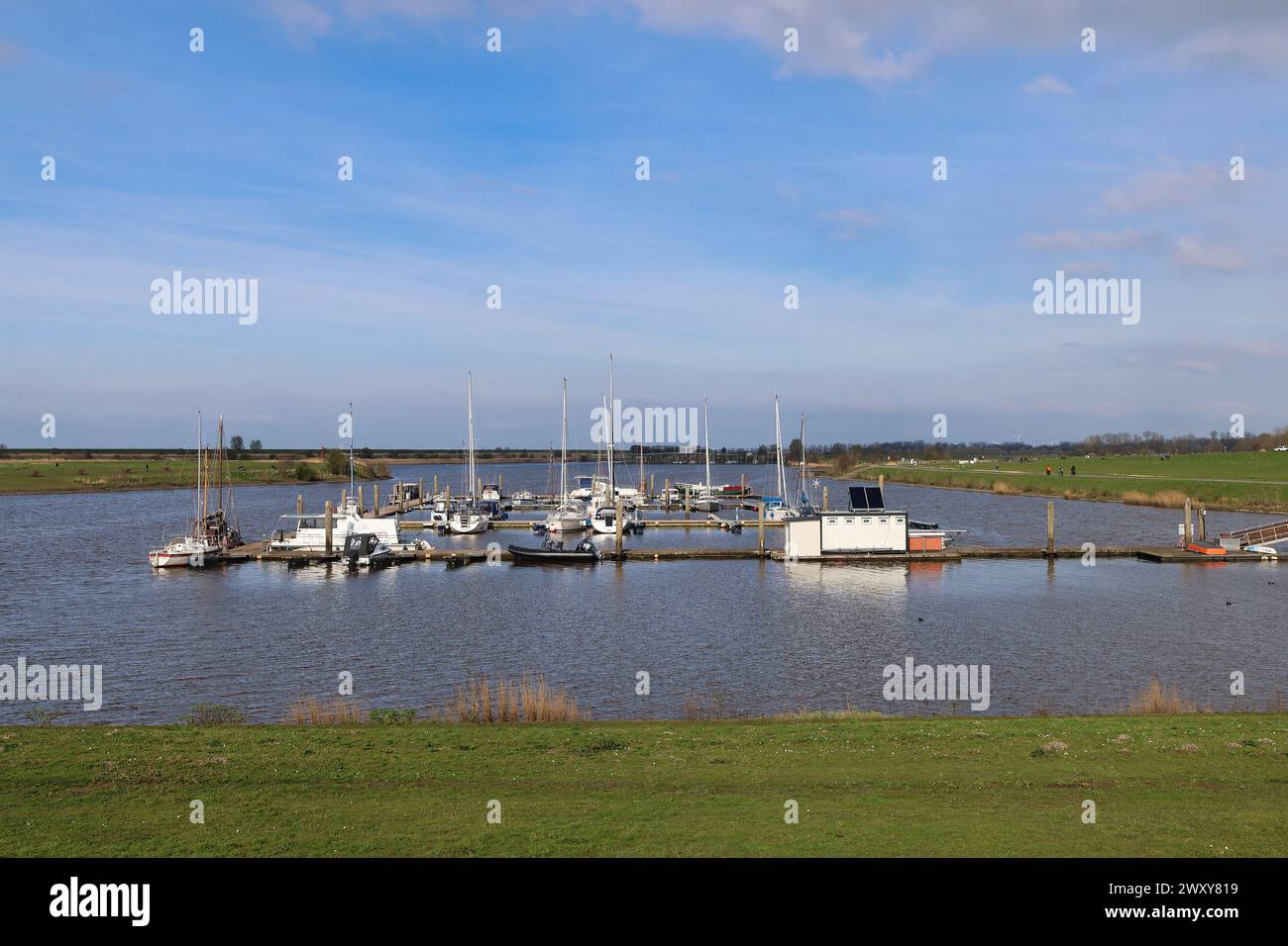 Eine Gruppe von Segelbooten, die in einem friedlichen Hafen in Ostfriesland vor Anker gebracht wurden Stockfoto