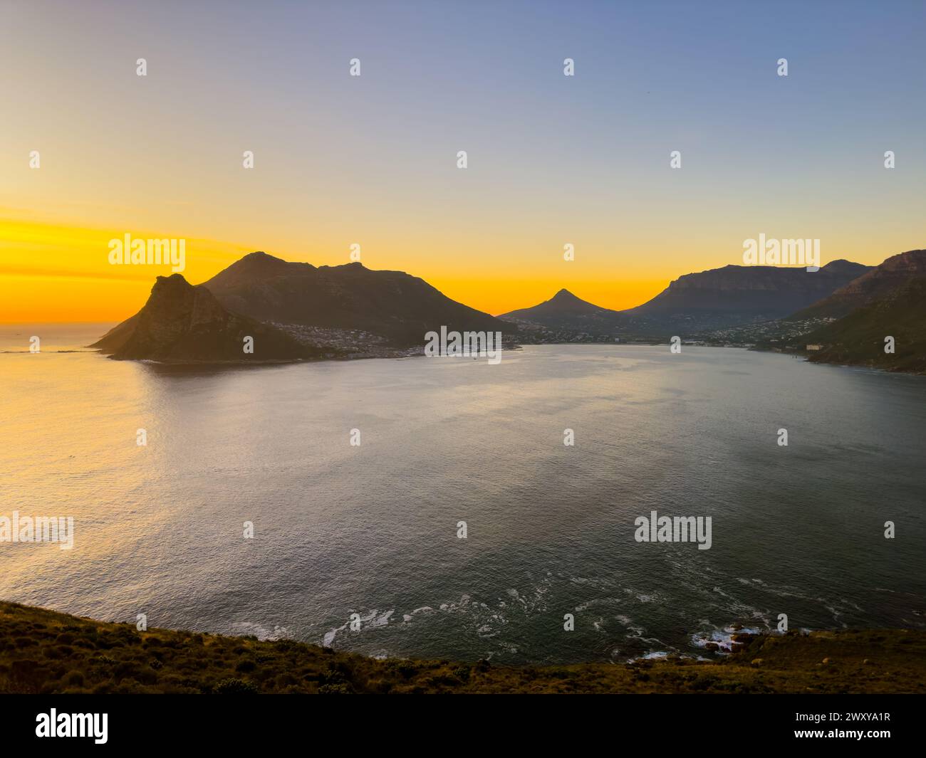 Die Berglandschaft an der Küste von Hout Bay bei Sonnenuntergang in Kapstadt, Südafrika Stockfoto