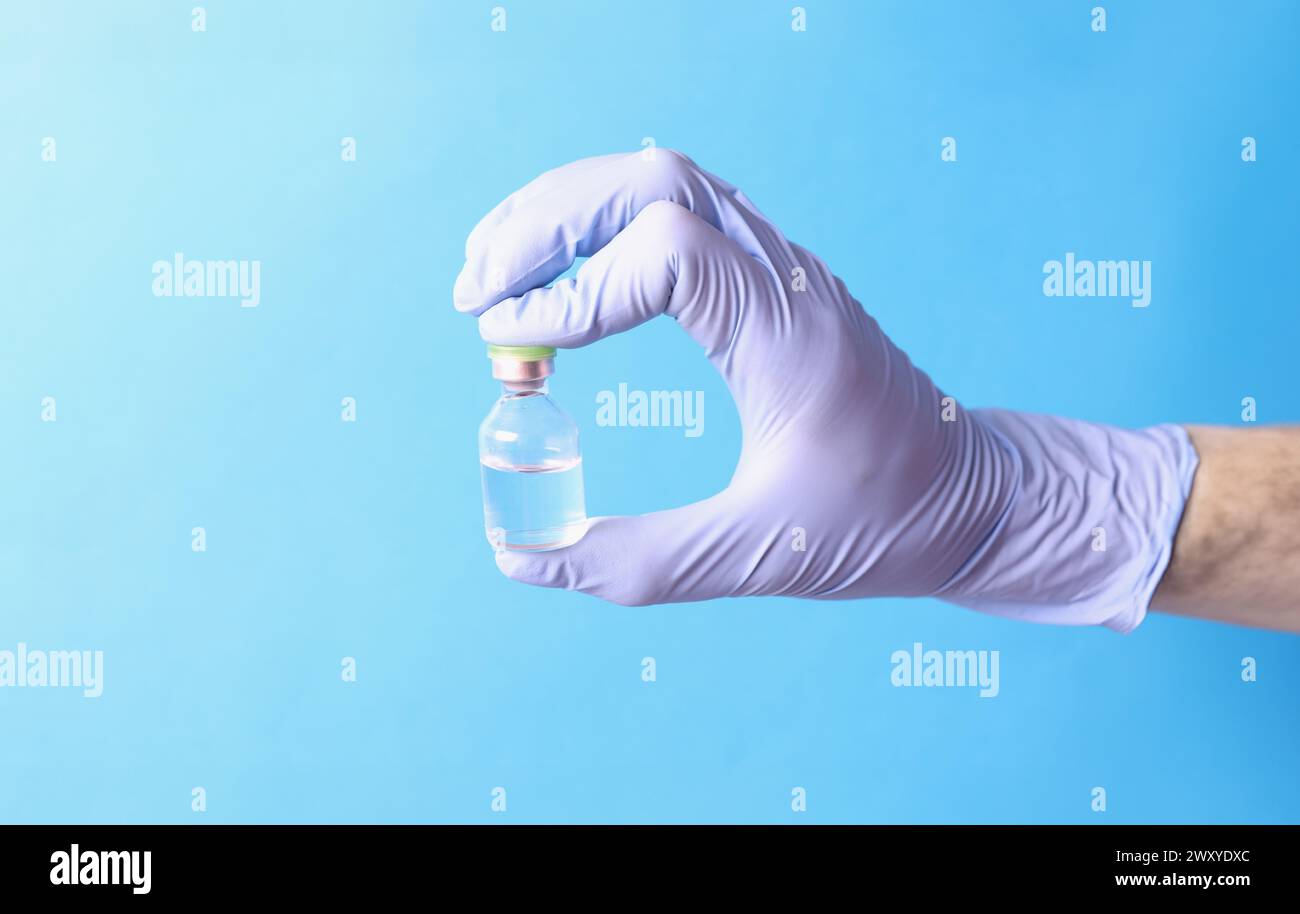 Arzt hält Glasampulle mit Medizin in Gummihandschuhen Nahaufnahme Stockfoto