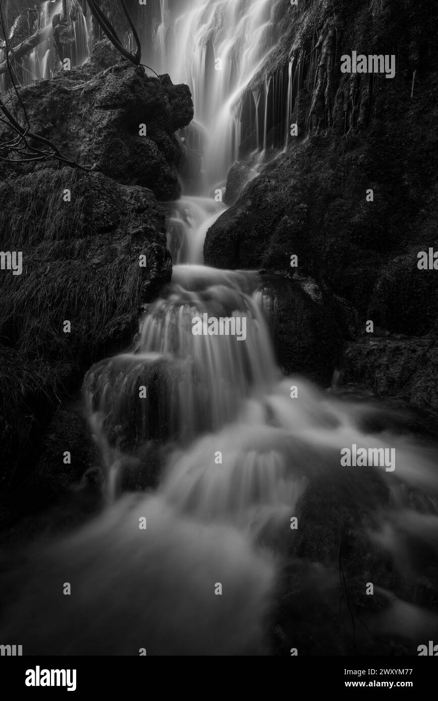 Mystische Wasserhüllen, die den Rio Mundo Wasserfall hinunterfließen, in Schwarz-weiß gefangen, und heben die fließende Kunst der Natur hervor Stockfoto