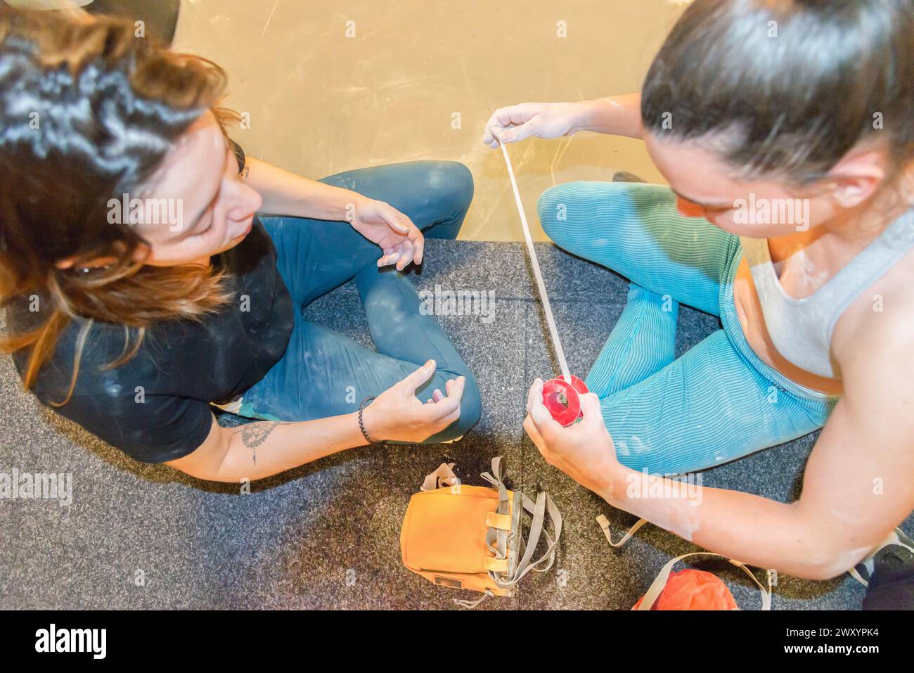 Zwei Bergsteiger arbeiteten in Teamarbeit und vermessen ein Kletterseil auf dem Boden vor dem Aufstieg akribisch Stockfoto