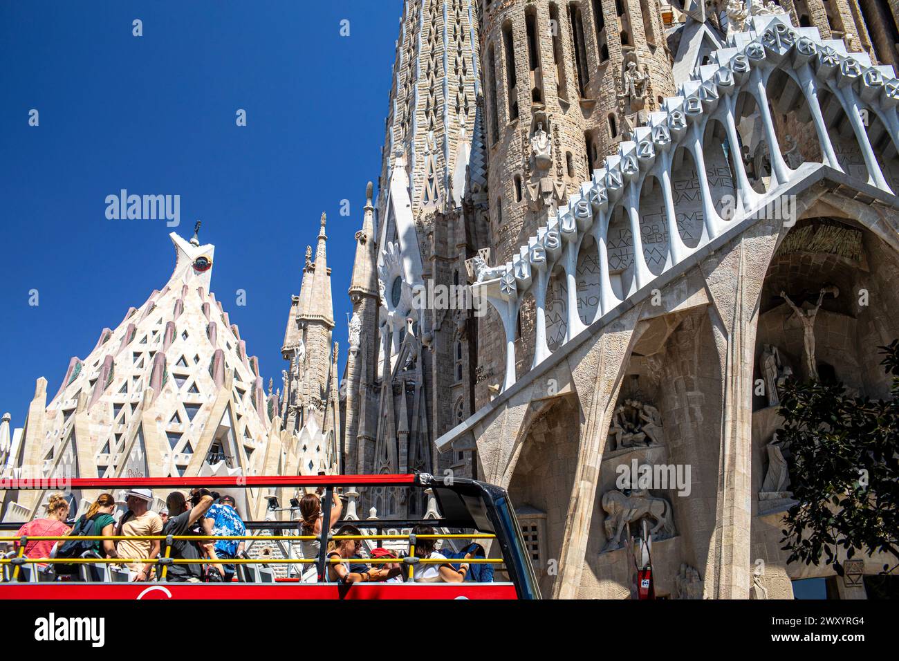 Spanien, Barcelona: Außenansicht der Sagrada Familia, entworfen vom Architekten Gaudí, ein UNESCO-Weltkulturerbe. Bus mit Touristen vor dem Stockfoto