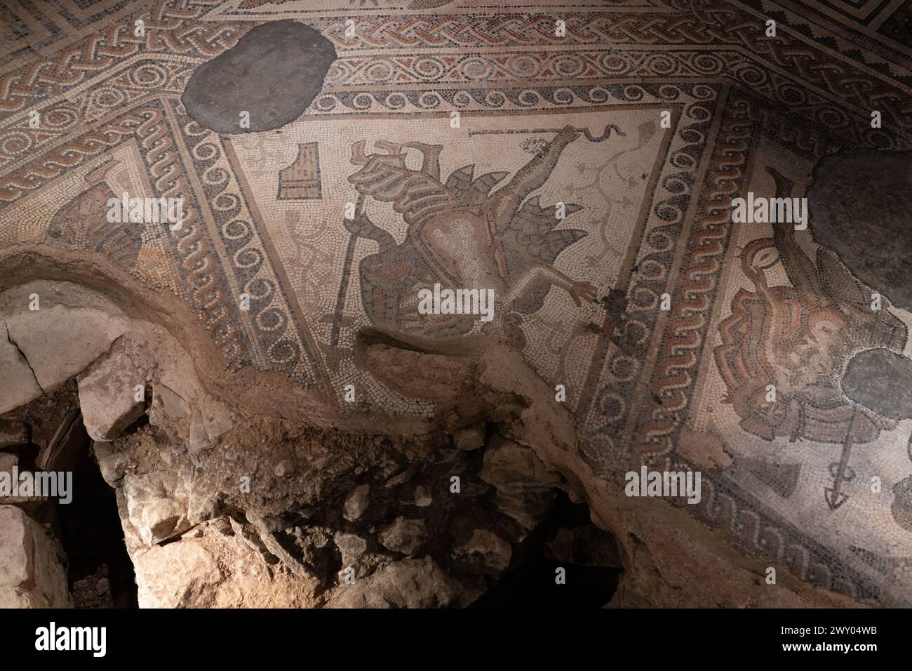 Das TriClinium (Speisesaal) im westlichen Bereich der Chedworth Roman Villa. Der Mosaikboden zeigt Mythen, die mit Bacchus, dem Gott des Weines, verbunden sind. UK Stockfoto