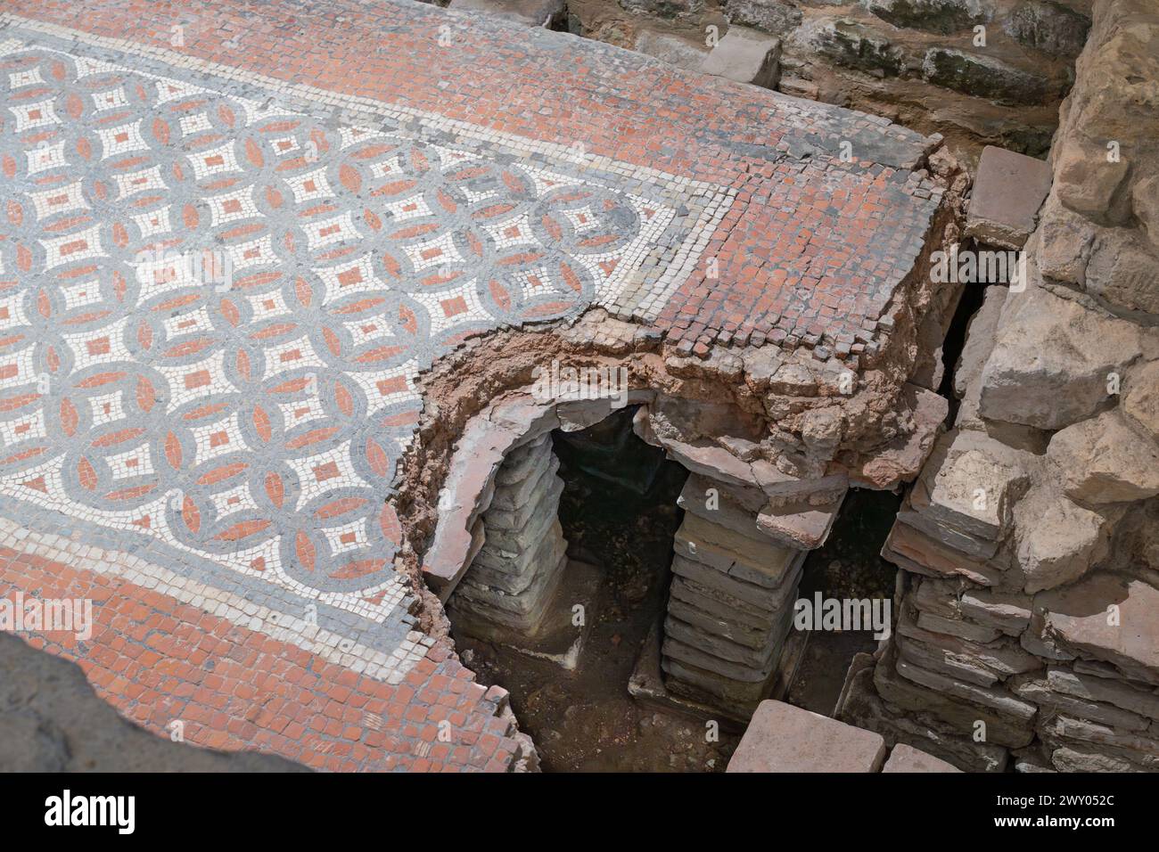 Westbadehaus in der Chedworth Roman Villa mit einem Hypokaukasus und kleinen Backsteinsäulen (Pilae), die einen Mosaikboden im Tepidarium (warmes Zimmer), Großbritannien, stützen Stockfoto