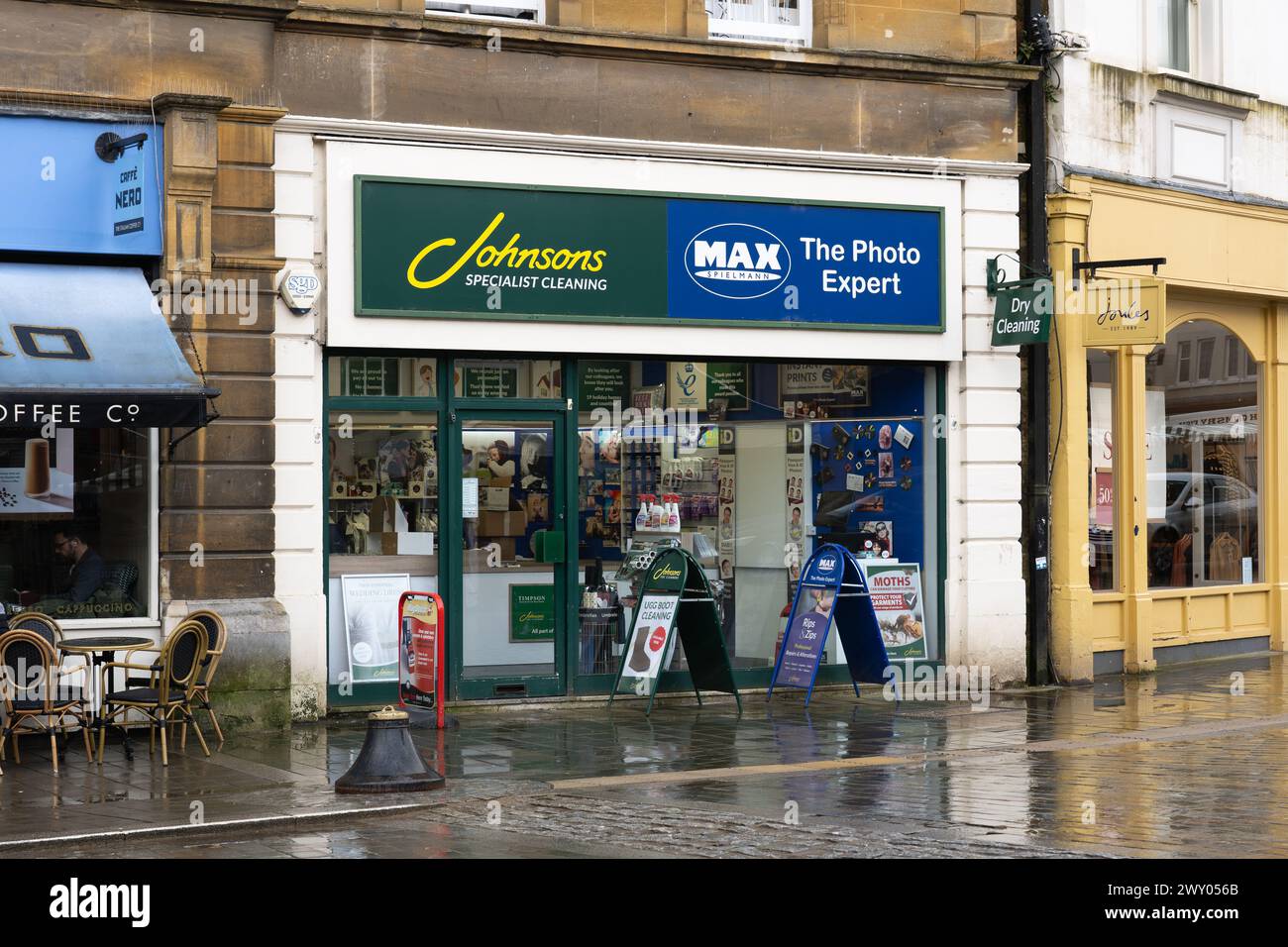 Ein kombinierter Johnsons Specialist Cleaning und Max Spielmann Photo Expert Shop auf dem Market Place, Cirencester. Konzept: Einkaufsstraße Stockfoto