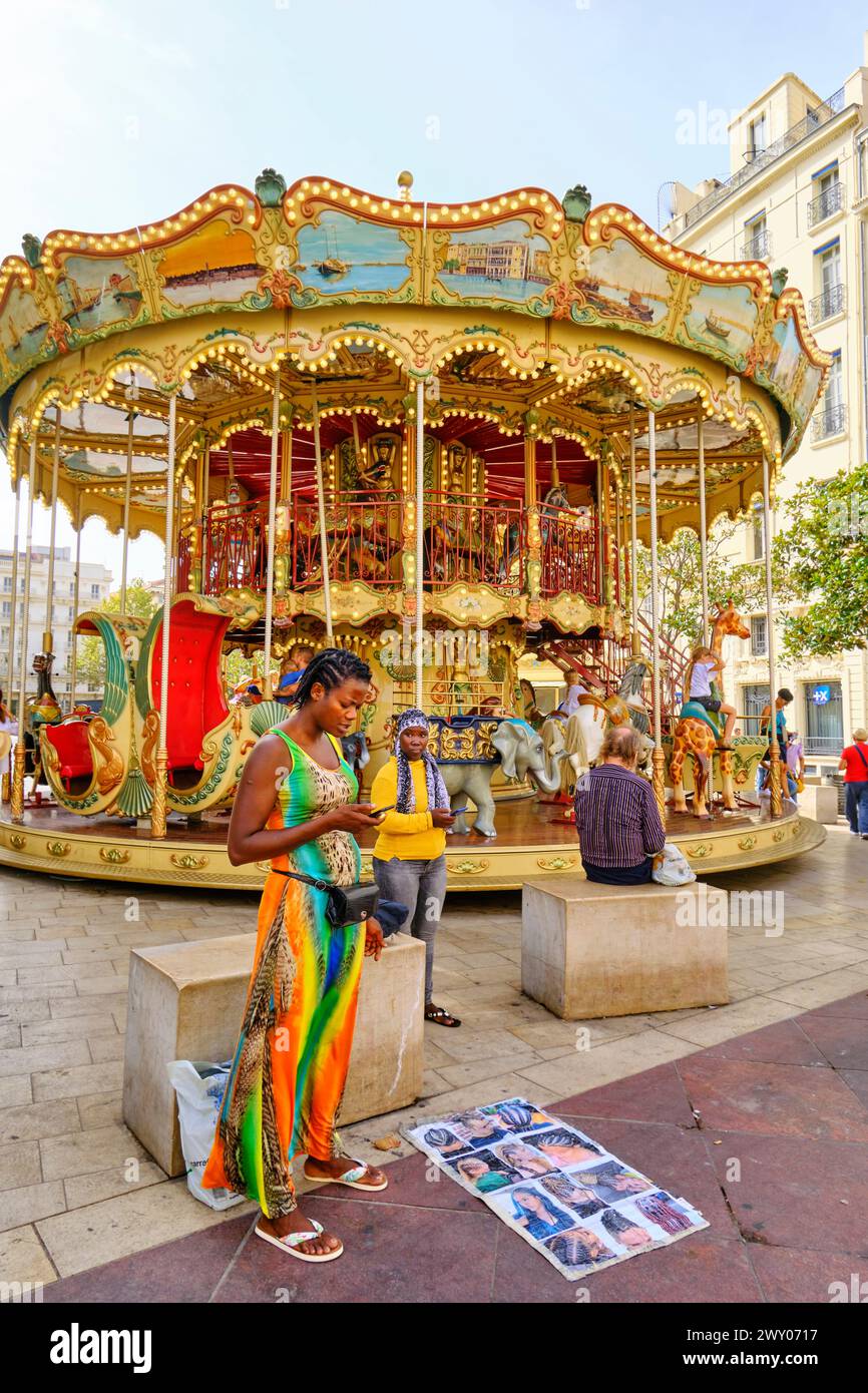 Altes Karussell und Multikulturalismus in La Canebière, einer der Hauptstraßen im Stadtzentrum, Marseille. Frankreich Stockfoto