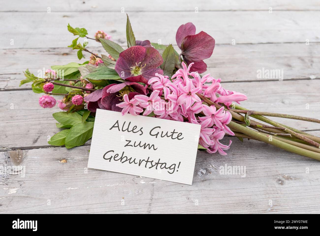Grußkarte mit Blumenstrauß aus blauen Hyazinthen und Karte mit deutschem Text: Happy Birthday Stockfoto