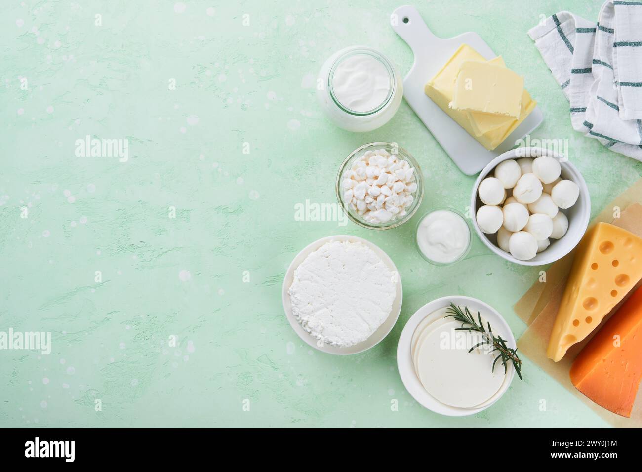 Milcherzeugnisse oder landwirtschaftliche Erzeugnisse. Frische Bio-Milchprodukte Milch, Hüttenkäse, Butter, Sahne, Joghurt, Sauerrahm und Mozzarella auf einem hellgrünen Stockfoto