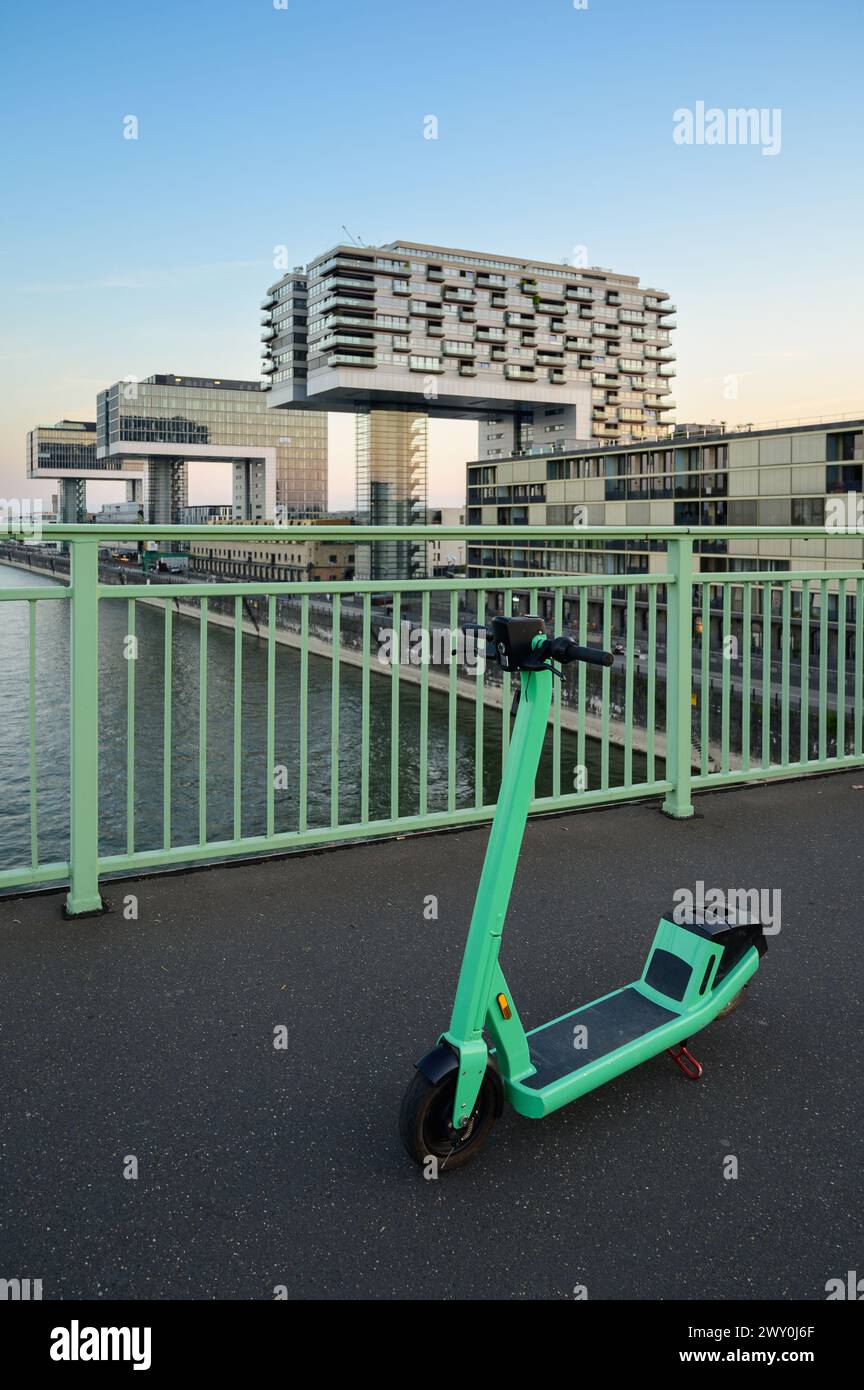 Ein einsamer Roller auf einer Brücke in Köln. Die sogenannten Kranhäuser im Hintergrund Stockfoto