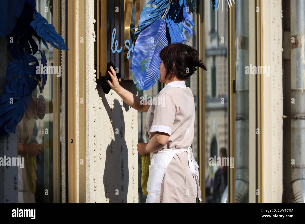 In der Stadt putzen, asiatische Frau wäscht die Restaurantfassade Stockfoto