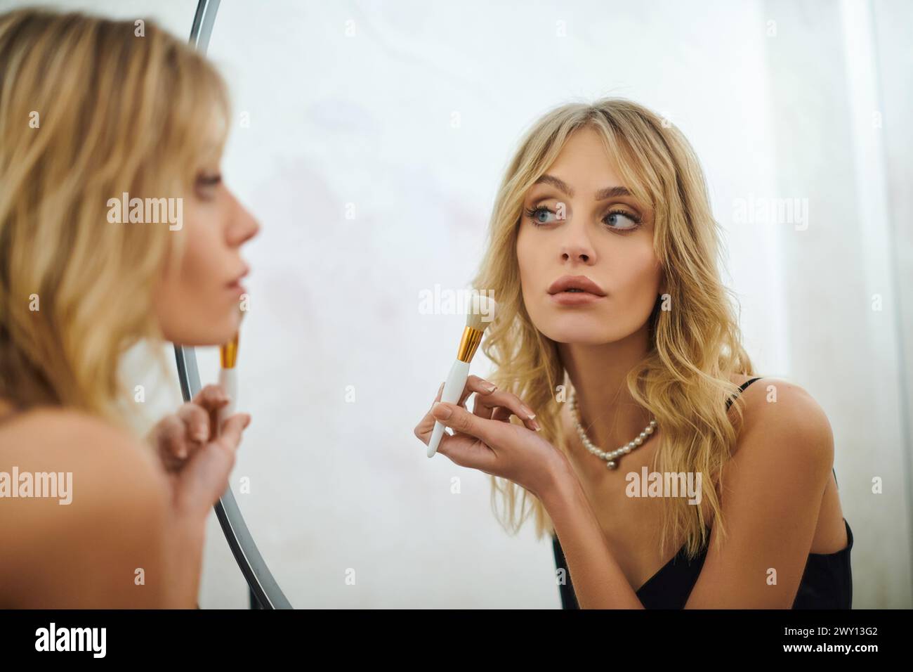 Eine Frau, die ihr Spiegelbild in einem Spiegel ansieht. Stockfoto
